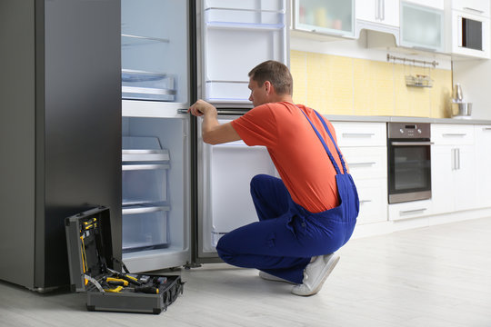 Expert Technician Servicing Refrigerator at Home - Universal Home Enterprises